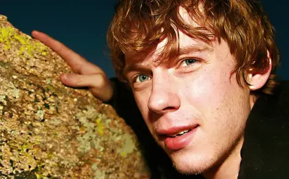 image of a man leaning on a rock