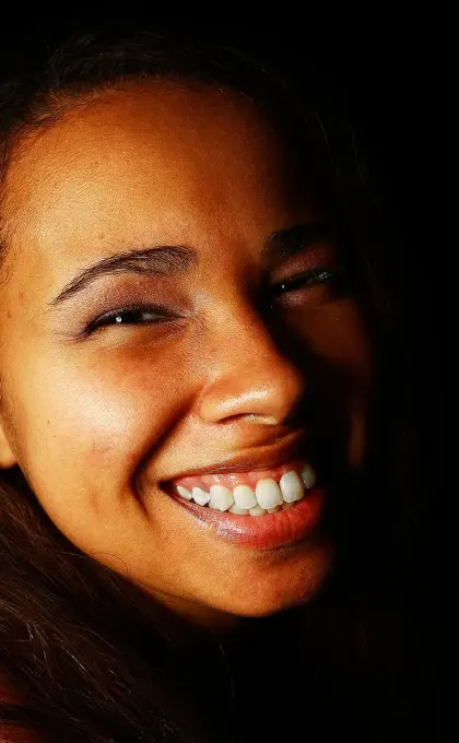 partially lit photo of a woman smiling